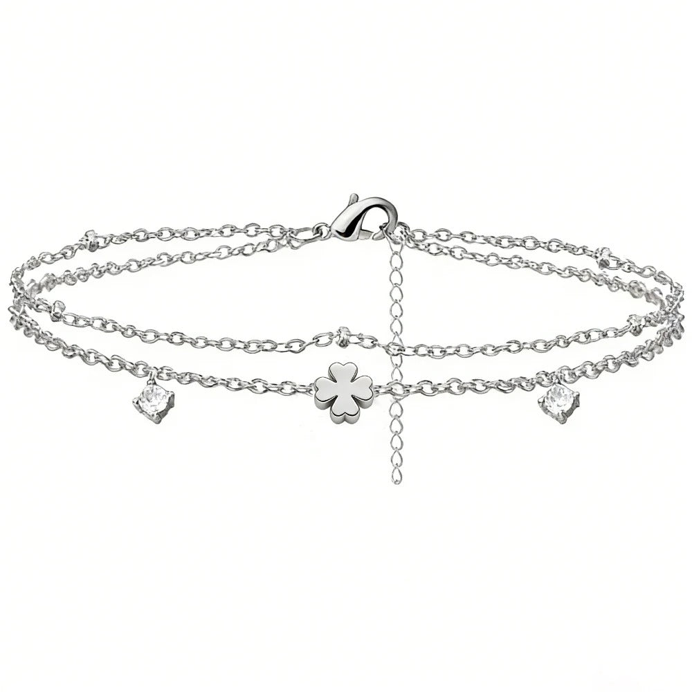 Silver anklet with clover and heart charms on a white background